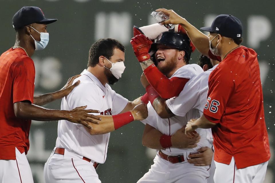 Boston Red Sox's Alex Verdugo, center, right, celebrates his walk-off RBI single with teammates during the ninth inning of a baseball game against the Cleveland Indians, Saturday, Sept. 4, 2021, in Boston. (AP Photo/Michael Dwyer)