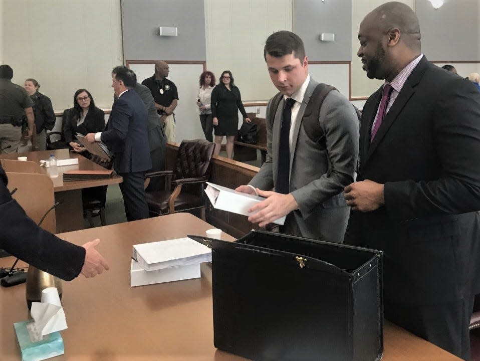 Jarrod Miller, right, plaintiff in the lawsuit against the District Attorney, speaks with attorney Tyler Gaines after the hearing was recessed.