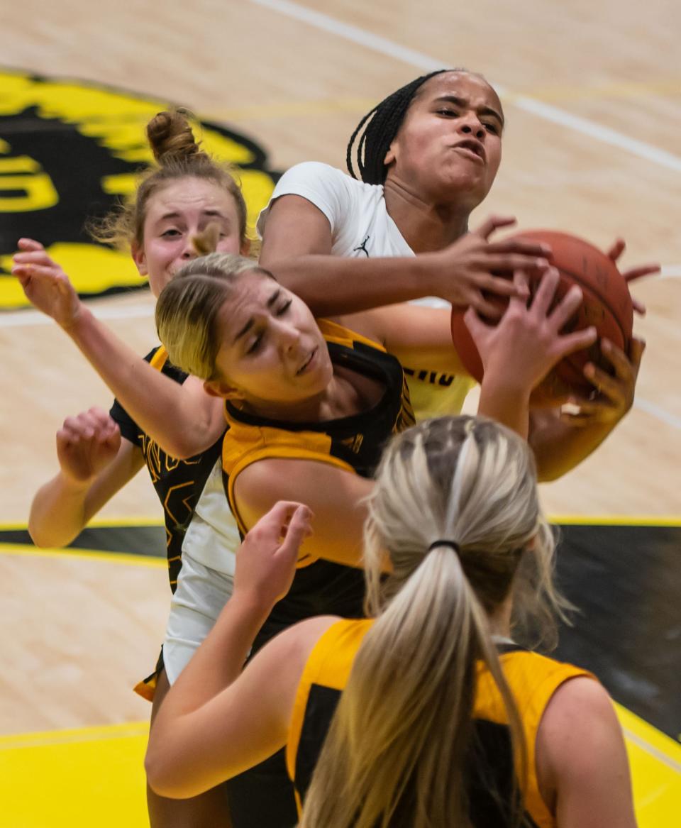 Quaker Valley's Zora Washington goes up for a rebound surrounded by Montour defenders during their game Friday at Montour High School. [Lucy Schaly/For BCT]