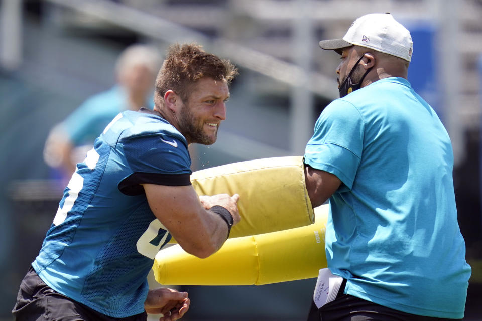 FILE - Jacksonville Jaguars tight end Tim Tebow, left, performs a drill during an NFL football team practice in Jacksonville, Fla., in this Thursday, May 27, 2021, file photo. Tebow will open training camp Wednesday, July 28 as Jacksonville’s fourth- or fifth-string tight end, not all that surprising given he’s closing in on his 34th birthday, started playing the position five months ago and is trying to return to the NFL after spending the previous five years in the New York Mets’ organization. (AP Photo/John Raoux, File)