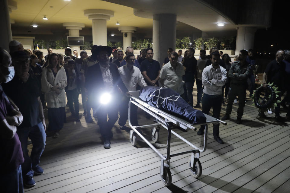 Mourners attend the funeral of Leah Yom Tov, 63, at a cemetery in Rishon Lezion, Israel, Wednesday, May 12, 2021. Yom Tov was killed from a rocket that was fired from Gaza Strip and hit her house in Rishon Lezion on May 11. (AP Photo/Sebastian Scheiner)