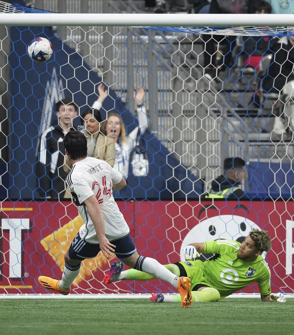 Minnesota United goalkeeper Dayne St. Clair, back right, stops Vancouver Whitecaps' Brian White as the ball deflects over the top of the goal during the first half of an MLS soccer match in Vancouver, British Columbia., Saturday, May 6, 2023. (Darryl Dyck/The Canadian Press via AP)