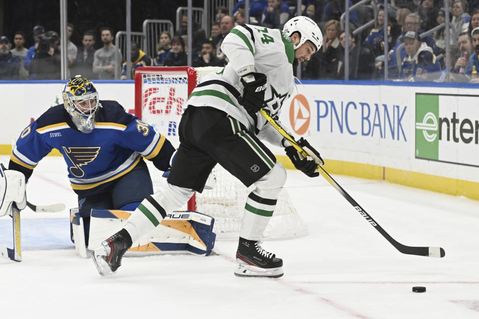 Dallas Stars' Jamie Benn (14) works the puck against St. Louis Blues' Joel Hofer (30) during the first period of an NHL hockey game Wednesday, Dec. 27, 2023, in St. Louis. (AP Photo/Michael Thomas)