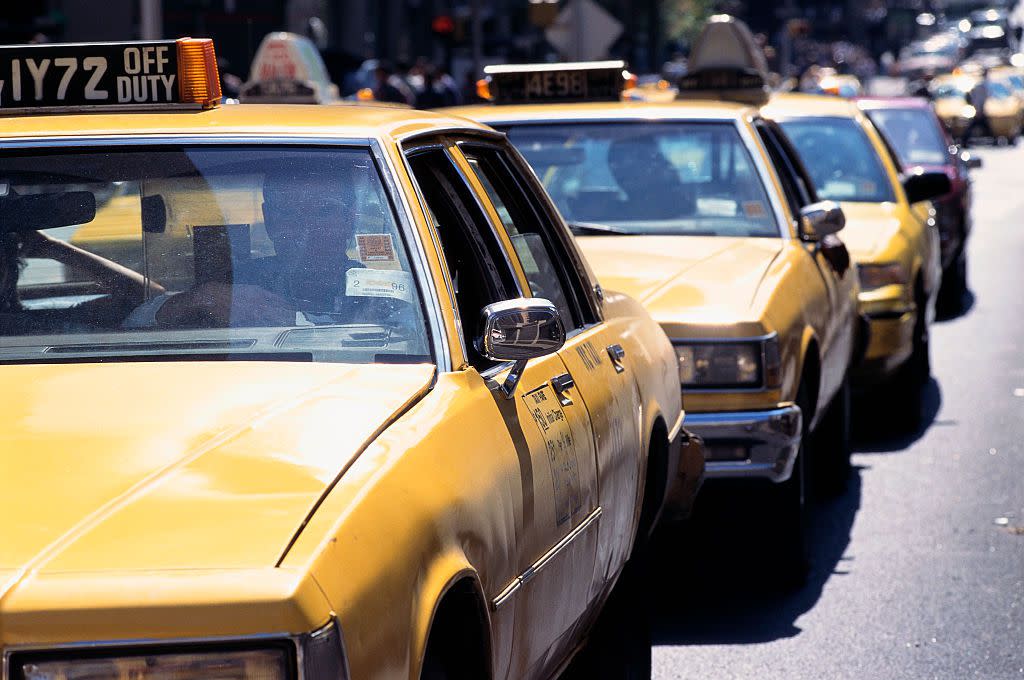 A line of taxis move through a traffic lane in New York City