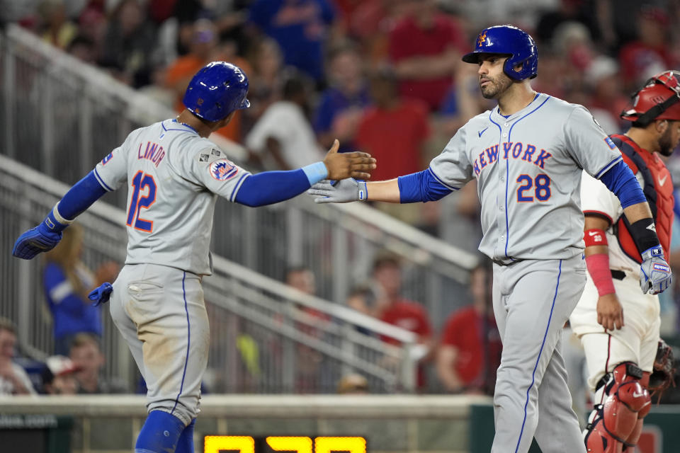 New York Mets' J.D. Martinez (28) is congratulated by teammate Francisco Lindor (12) after hitting a three-run home run during the 10th inning of a baseball game against the Washington Nationals at Nationals Park, Monday, July 1, 2024, in Washington. (AP Photo/Mark Schiefelbein)