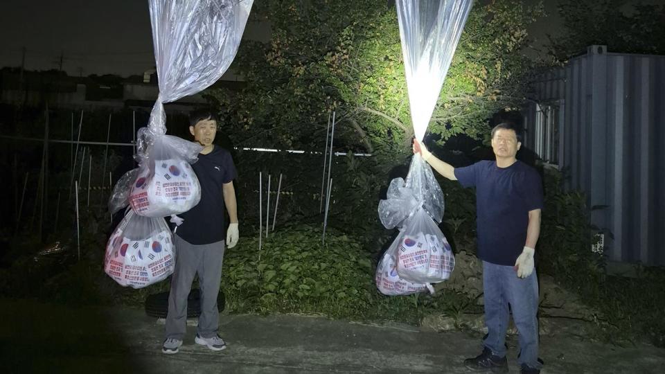 North Korean defector Park Sang-hak (L) with balloons with propaganda