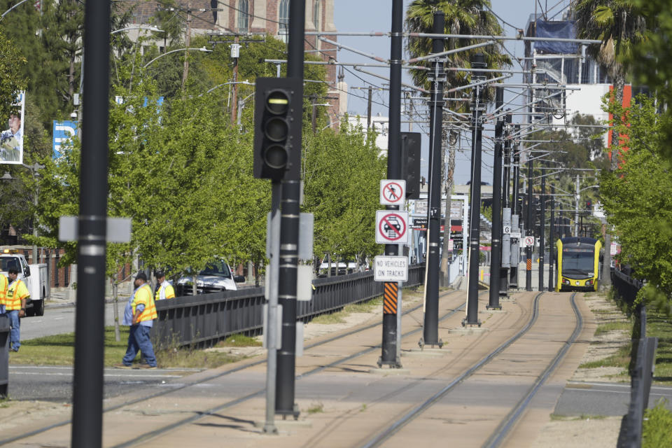 A Metro light rail train returns to service in Los Angeles, Tuesday, April 30, 2024. The LA Fire Department says a crash happened shortly before noon Tuesday along Exposition Boulevard, near the USC campus and the Natural History Museum. Officials say multiple people were hurt when a train and a University of Southern California shuttle bus collided. (AP Photo/Damian Dovarganes)