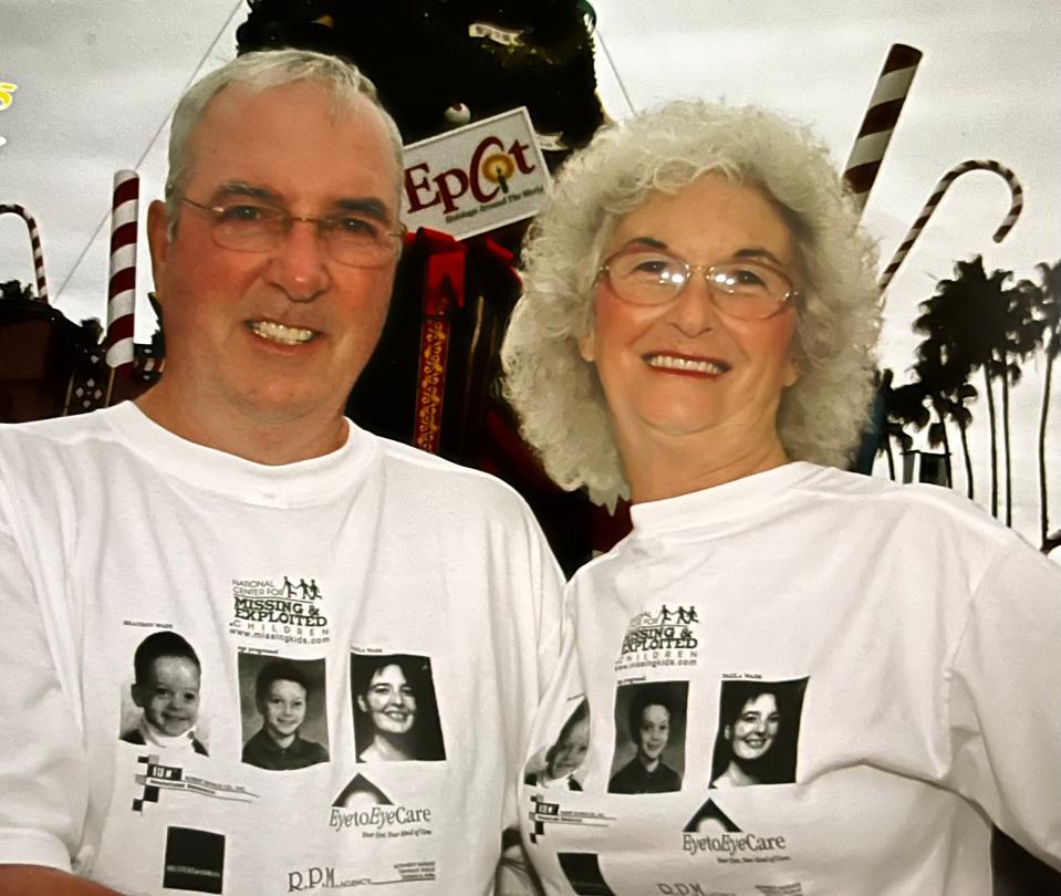 Regis McGrath Sr., left, and Mary McGrath, right, post for a photo at Epcot in 2005, wearing shirts featuring an image of their grandson, Brandon Wade, who went missing along with his mother, Paula Wade, in October 2002.