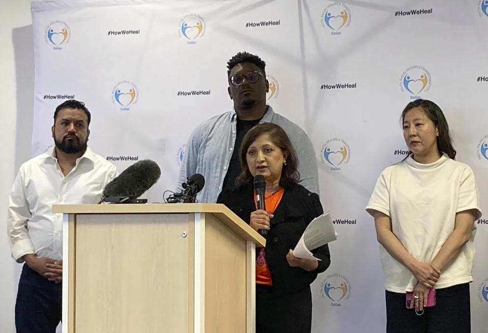 Chanda Parbhoo, at podium, founder and president of SAAVETX Education Fund, speaks at a news conference as, from left rear, Ramiro Luna, executive director and co-founder of Somos Tejas; Jerry Hawkins of Dallas Truth, Racial Healing & Transformation; and community member Caroline Kim listen, Monday, May 15, 2023, in Dallas. Members of Texas groups representing people of color demanded that authorities quickly acknowledge whether they believe the neo-Nazi who killed eight people at a Dallas-area mall over a week ago was racially motivated in choosing his victims. (AP Photo/Jamie Stengle)
