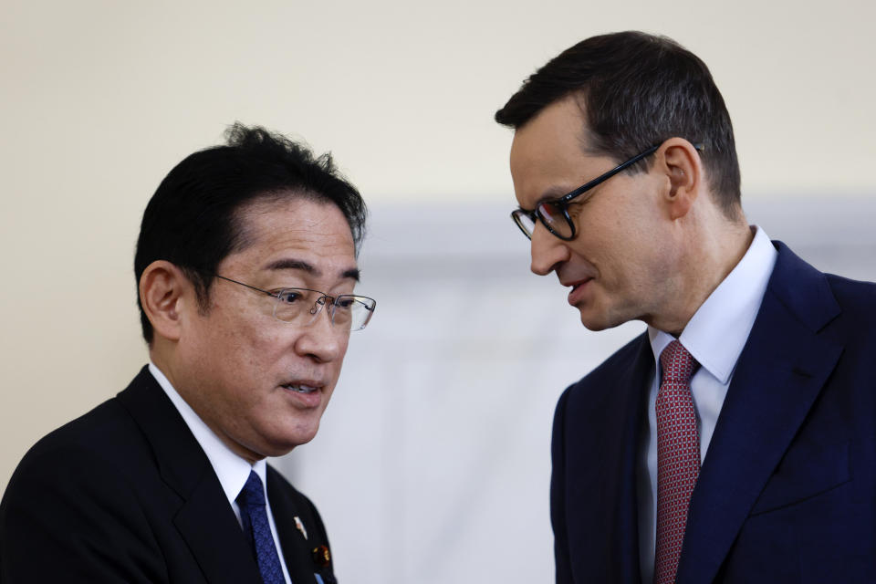 Polish Prime Minister Mateusz Morawiecki, right, and Japanese Prime Minister Fumio Kishida, left, talking after a press conference in Warsaw, Poland, Wednesday, March 22, 2023. (AP Photo/Michal Dyjuk)