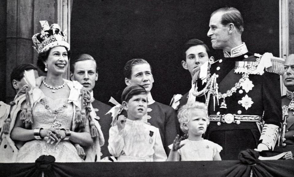 Buckingham Palace balcony. Coronation day 1953. The Queen and the Duke exchange smiles while Prince Charles and Princess Anne are absorbed with the planes roaring overhead. (Photo by: Universal History Archive/Universal Images Group via Getty Images)