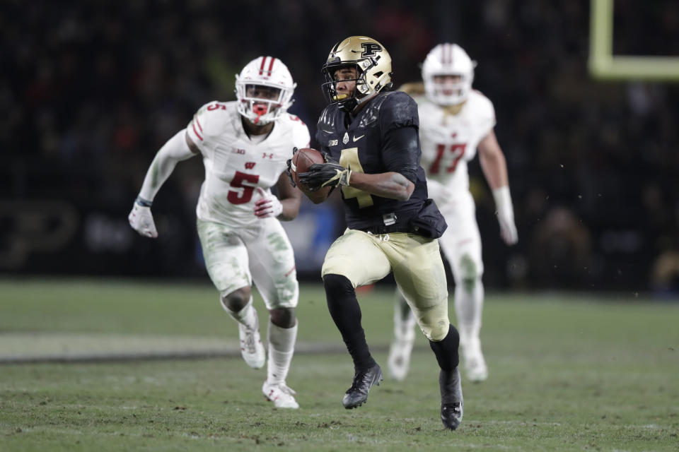 Purdue wide receiver Rondale Moore (4) makes a catch in front of Wisconsin cornerback Rachad Wildgoose (5) on his way to a touchdown during the second half of an NCAA college football game in West Lafayette, Ind., Saturday, Nov. 17, 2018. Wisconsin defeated Purdue 47-44 in overtime. (AP Photo/Michael Conroy)