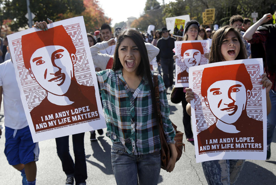 FILE - In this Oct. 29, 2013 file photo, protesters hold images of shooting victim Andy Lopez during a march in Santa Rosa, Calif. Sonoma County will pay $3 million to settle a civil rights lawsuit filed by the family of a California teenager who was fatally shot by a sheriff's deputy while holding a pellet gun. The Press Democrat reports the settlement was approved unanimously Tuesday, Dec. 18, 2018, by the county Board of Supervisors, bringing to a close a lawsuit filed in Nov. 2013 by the family of 13-year-old Lopez. (AP Photo/Marcio Jose Sanchez, File)