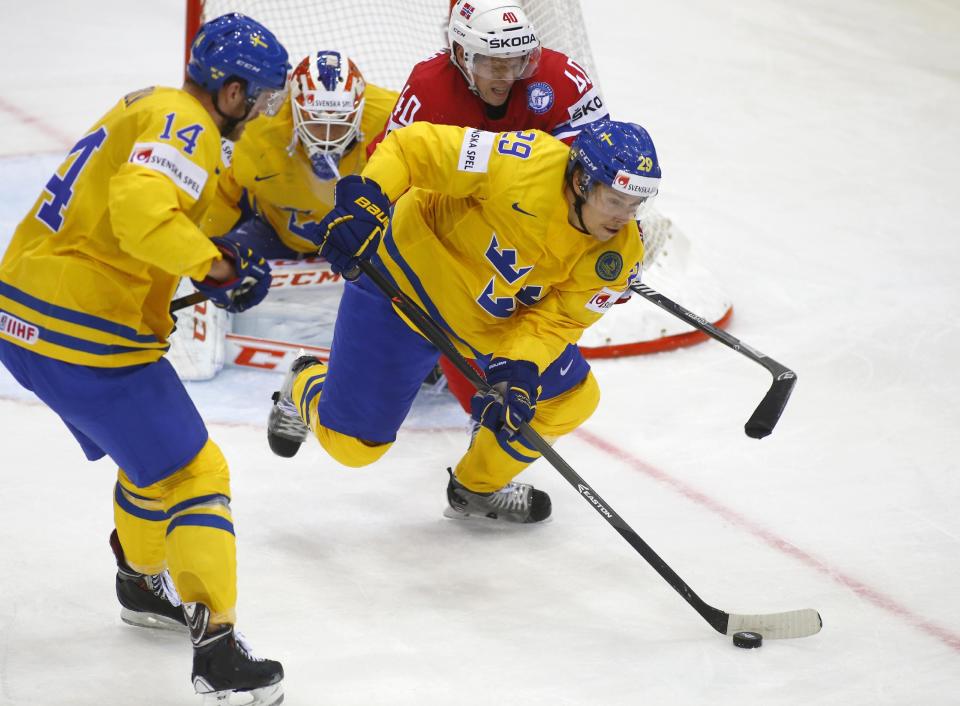 Norway's Ken Andre Olimb, top, and Sweden's Mattias Ekholm, left, Erik Gustafsson battle for the puck during the Group A preliminary round match at the Ice Hockey World Championship in Minsk, Belarus, Tuesday, May 13, 2014. (AP Photo/Sergei Grits)