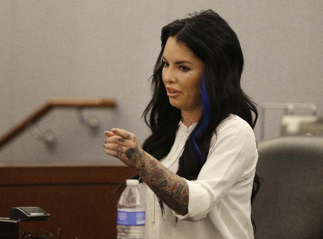 FILE - In this Nov. 14, 2014, file photo, Christine Mackinday, also known as Christy Mack, points toward Jonathan Paul Koppenhaver, also known as War Machine, during a preliminary hearing for Koppenhaver in Las Vegas, Nev. A jury is deliberating whether the former mixed martial arts fighter, Koppenhaver also named War Machine is guilty of charges that could get him life in prison in an attack on his porn star ex-girlfriend Mackinday, and her male friend in August 2015. (AP Photo/John Locher, file)