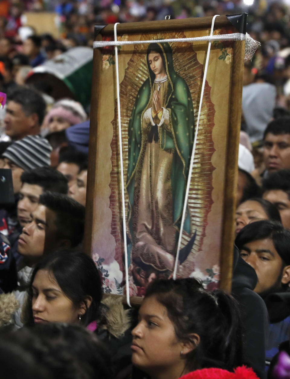 Gente con imágenes de la Virgen de Guadalupe llegan a la Basílica en Ciudad de México en la peregrinación anual, jueves 12 de diciembre de 2019. El coordinador de defensa civil, David León, estimó la concurrencia en 9,8 millones de personas, cifra superior a la población de la capital mexicana. (AP Foto/Marco Ugarte)