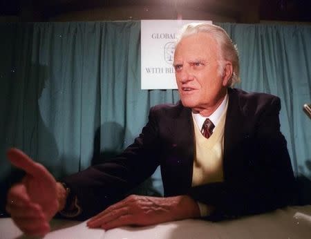 Evangelist Billy Graham talks with a supporter after a New York press conference on February 7, 1995 where he announced a global mission from March 16-18 via satellite that is expected to reach as many as 1 billion people in 165 countries. REUTERS/Mark Caldwell/File Photo