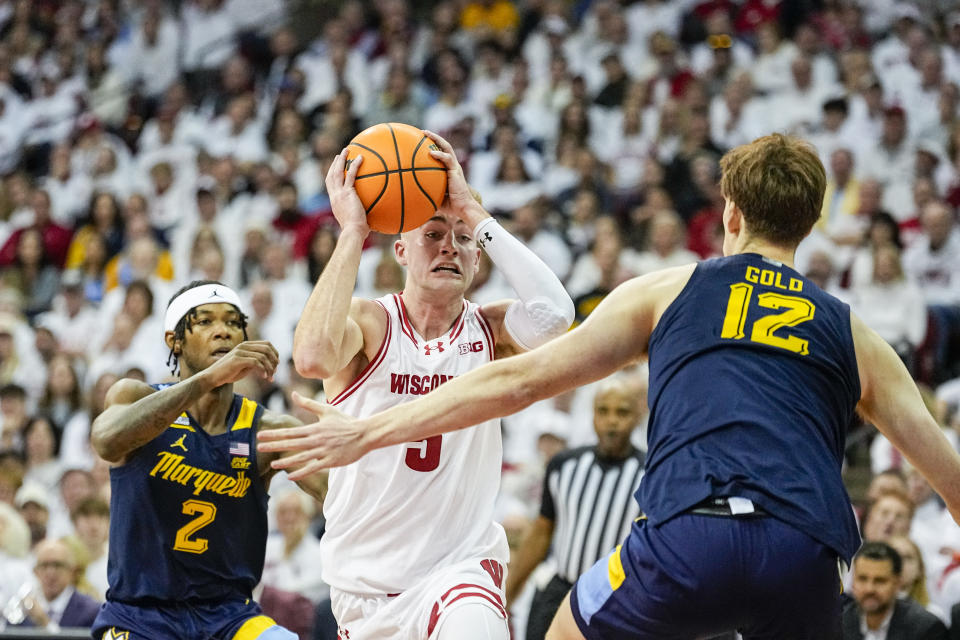 Wisconsin's Tyler Wahl (5) drives between Marquette's Chase Ross (2) and Ben Gold (12) during the second half of an NCAA college basketball game Saturday, Dec. 2, 2023, in Madison, Wis. (AP Photo/Andy Manis)