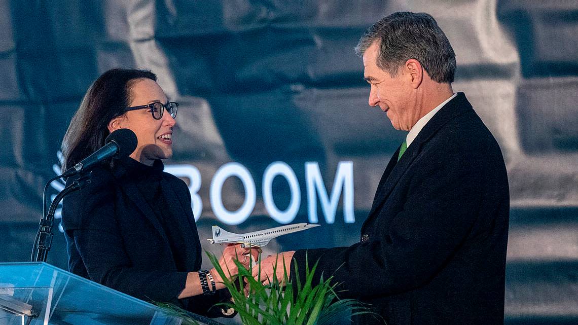 Boom Supersonic President and Chief Business Officer Kathy Savitt gives Gov. Roy Cooper a model of a proposed Overture supersonic jet during a press conference Wednesday, Jan. 26, 2022 at a Greensboroís Piedmont Triad International. The aviation startup plans to build a $500 million ìflagshipî production facility at the airport that is expected to create more than 1,750 jobs.