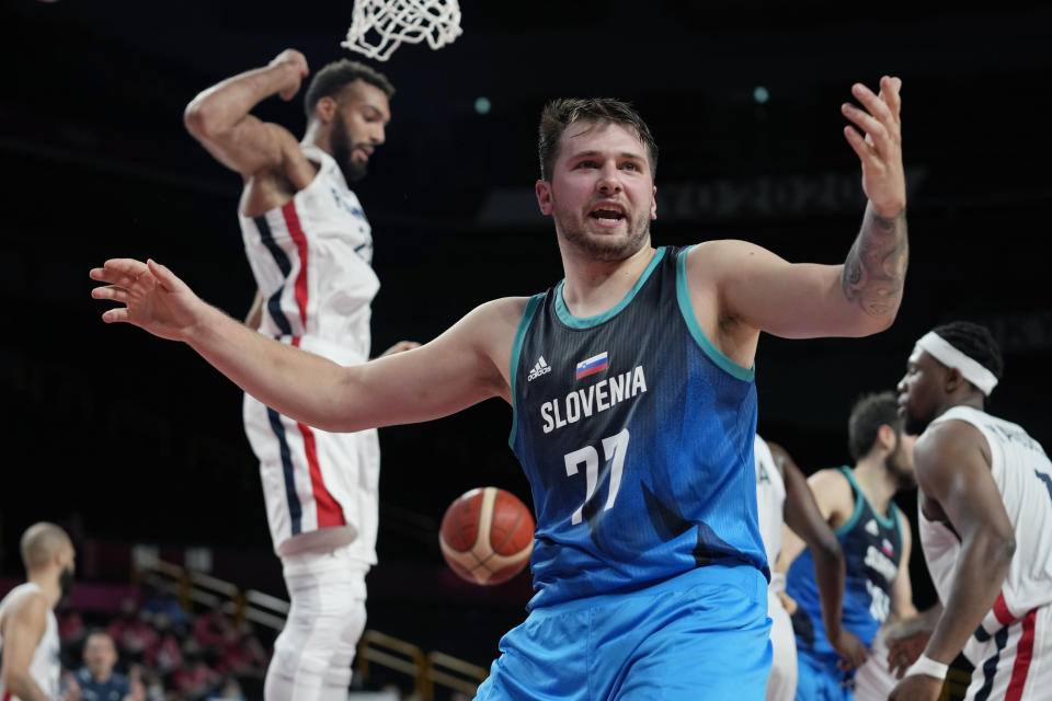 Slovenia's Luka Doncic (77) reacts after scoring against France's Rudy Gobert, left, during a men's basketball quarterfinal round game at the 2020 Summer Olympics, Thursday, Aug. 5, 2021, in Saitama, Japan. (AP Photo/Eric Gay)