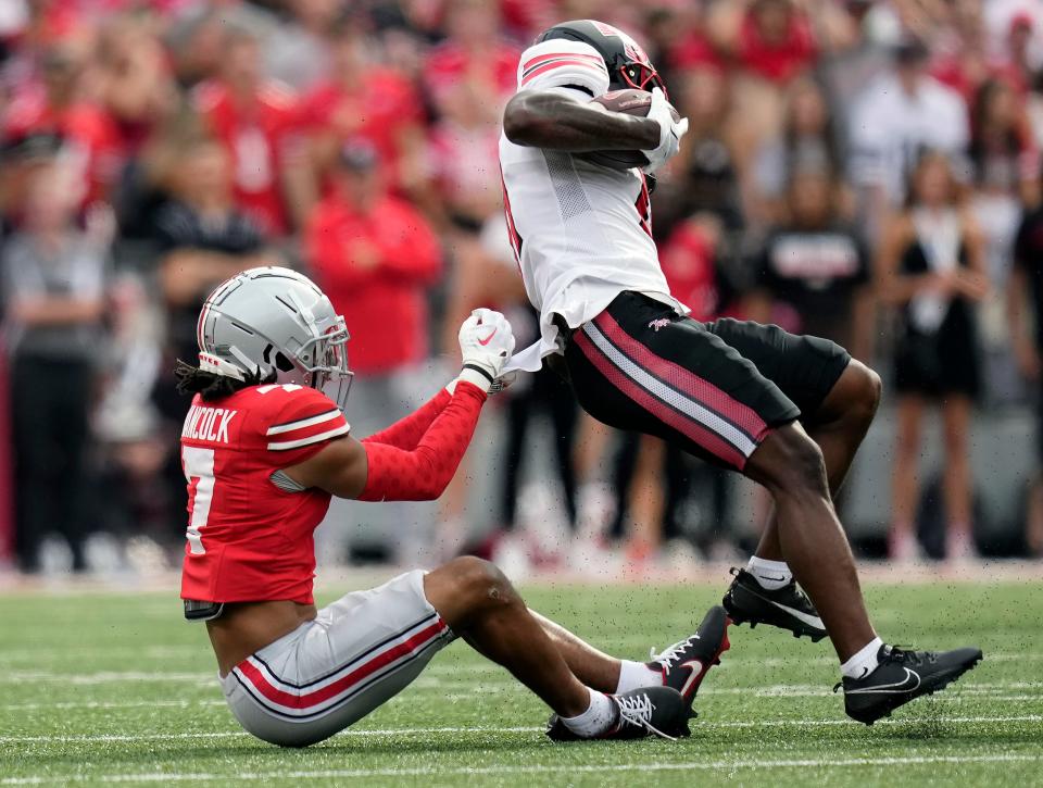 Ohio State cornerback Jordan Hancock (7) pulls down Western Kentucky wide receiver Malachi Corley (11) after a catch on Sept. 16 in Columbus.