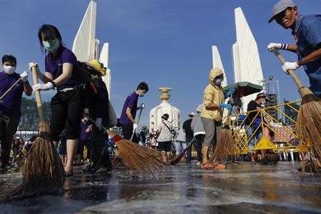 Anti-government protesters sweep the street around the Democracy monument after weeks of protesting and days of clashes with police in Bangkok's city centre December 4, 2013. REUTERS/Damir Sagolj