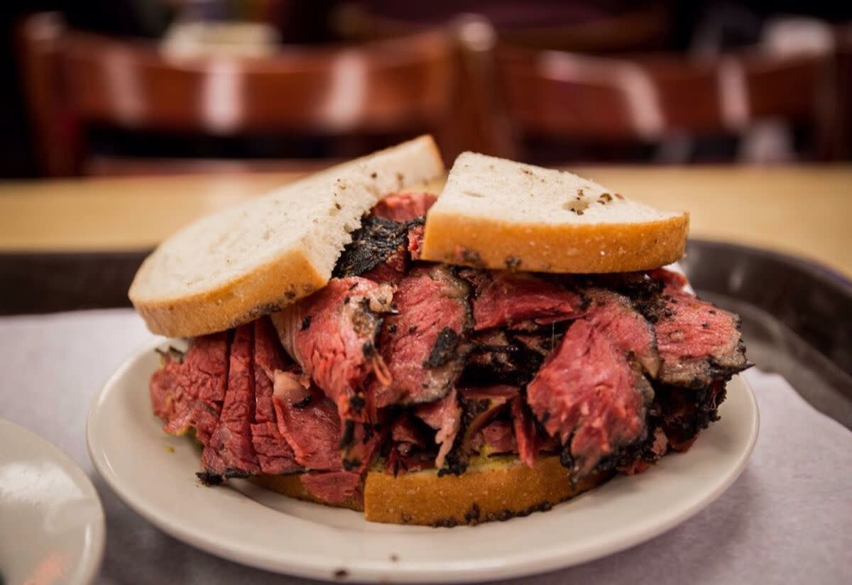 Pastrami on Rye on a white ceramic plate, Katz's Deli, New York City, selective focus, on a table blurred in the background