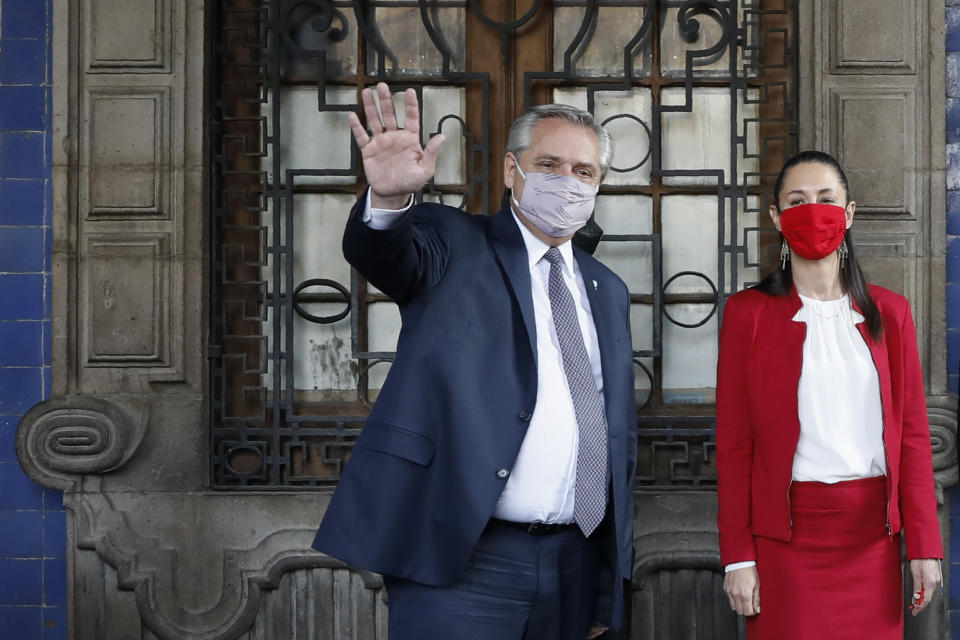 Argentine President Alberto Fernandez waves as he leaves the Old Town Hall with Mexico City Mayor Claudia Sheinbaum, in Mexico City, Tuesday, Feb. 23, 2021. Fernandez is on an official visit to Mexico.(AP Photo/Rebecca Blackwell)