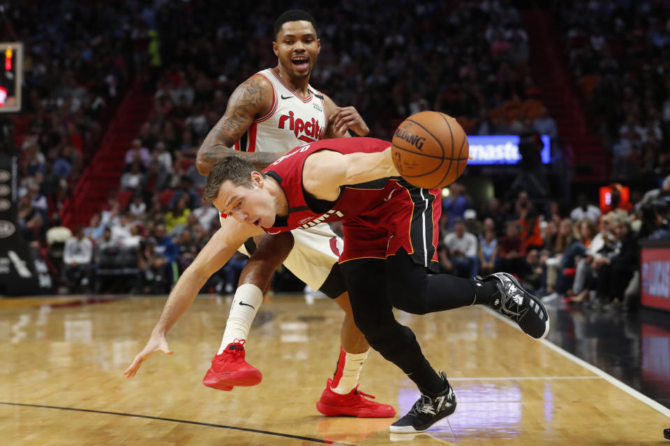 Miami Heat guard Goran Dragic, foreground, looses control of the ball as he drives past Portland Trail Blazers guard Kent Bazemore during the second half of an NBA basketball game, Sunday, Jan. 5, 2020, in Miami. Dragic had 29 points and 13 assists as the Heat defeated the Trail Blazers 122-111. (AP Photo/Wilfredo Lee)