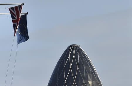A British Union Jack flag and an European Union flag fly from a building, with the 'Gherkin' skyscraper seen in the City of London financial district in London, Britain, January 30, 2016. REUTERS/Toby Melville