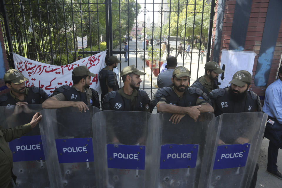 Police officers stand alert outside a hospital where Pakistan former Prime Minister Nawaz Sharif admitted in Lahore, Pakistan, Tuesday, Oct. 22, 2019. Sharif, who was convicted on corruption charges, has been rushed to hospital from the prison after recent blood tests raised doctors' concerns. (AP Photo/K.M. Chaudary)