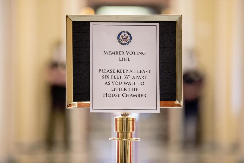 A sign in the hallway outside the House Chamber gives social distancing guidelines to lawmakers on Capitol Hill, Thursday, April 23, 2020, in Washington. The House is expected to vote on a nearly $500 billion Coronavirus relief bill. (AP Photo/Andrew Harnik)