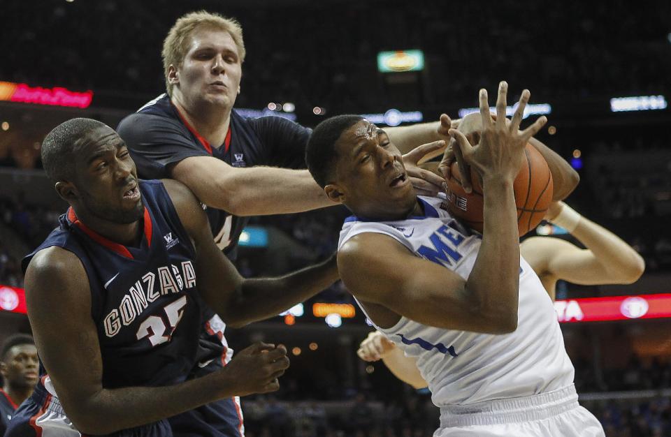 Memphis forward Nick King, right, tries to hang onto a rebound against Gonzaga center Sam Dower Jr. (35) and center Przemek Karnowski, back, in the second half of an NCAA college basketball game on Saturday, Feb. 8, 2014, in Memphis, Tenn. Memphis won 60-54. (AP Photo/Lance Murphey)