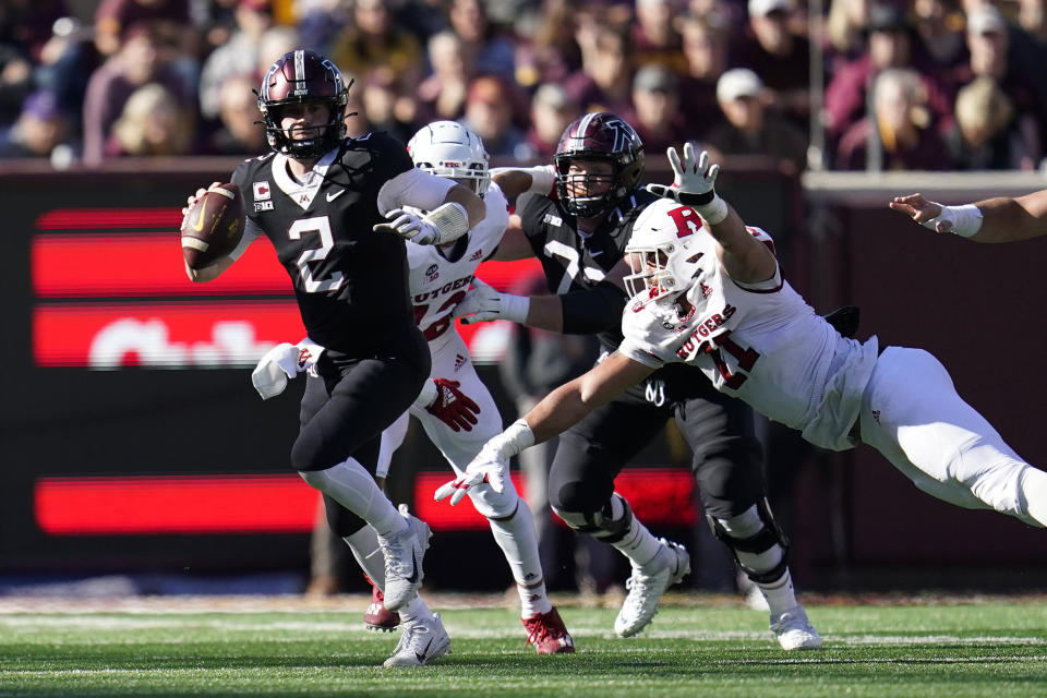 Minnesota quarterback Tanner Morgan (2), left, scrambles during the first half of an NCAA college football game against Rutgers, Saturday, Oct. 29, 2022, in Minneapolis. (AP Photo/Abbie Parr)