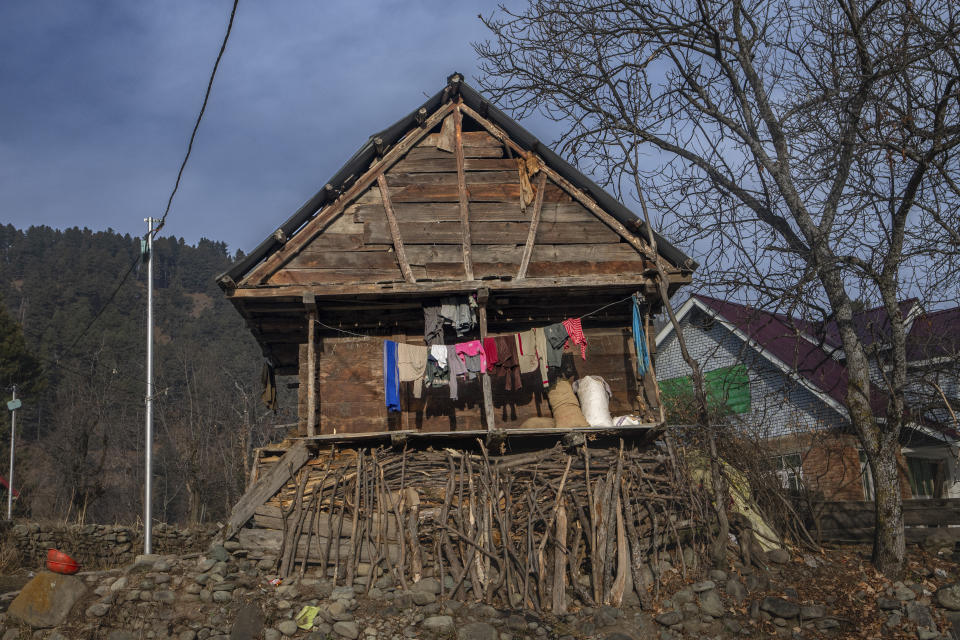 Firewood used for cooking and heating is stored under the hut in Drang village northwest of Srinagar, Indian controlled Kashmir Friday, Dec. 22, 2023. In the hilly areas of Kashmir, most villagers depend on firewood for cooking and heating during the winter season. (AP Photo/Dar Yasin)