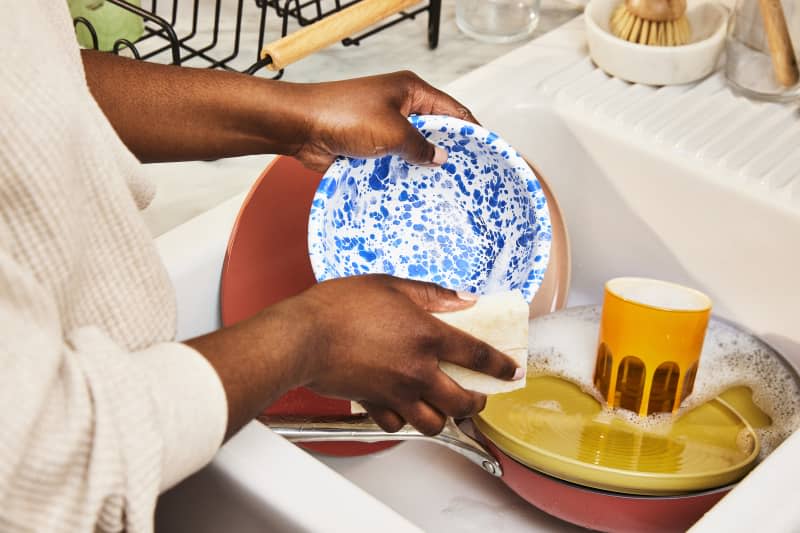 Person washing dishes at a kitchen sink