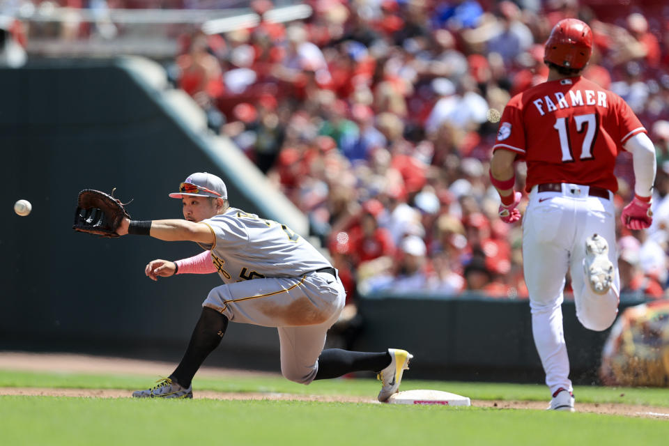 Pittsburgh Pirates' Yoshi Tsutsugo fields the ball at first base on a ground out by Cincinnati Reds' Kyle Farmer (17) during the fourth inning of a baseball game against of a doubleheader in Cincinnati, Sunday, May 8, 2022. (AP Photo/Aaron Doster)