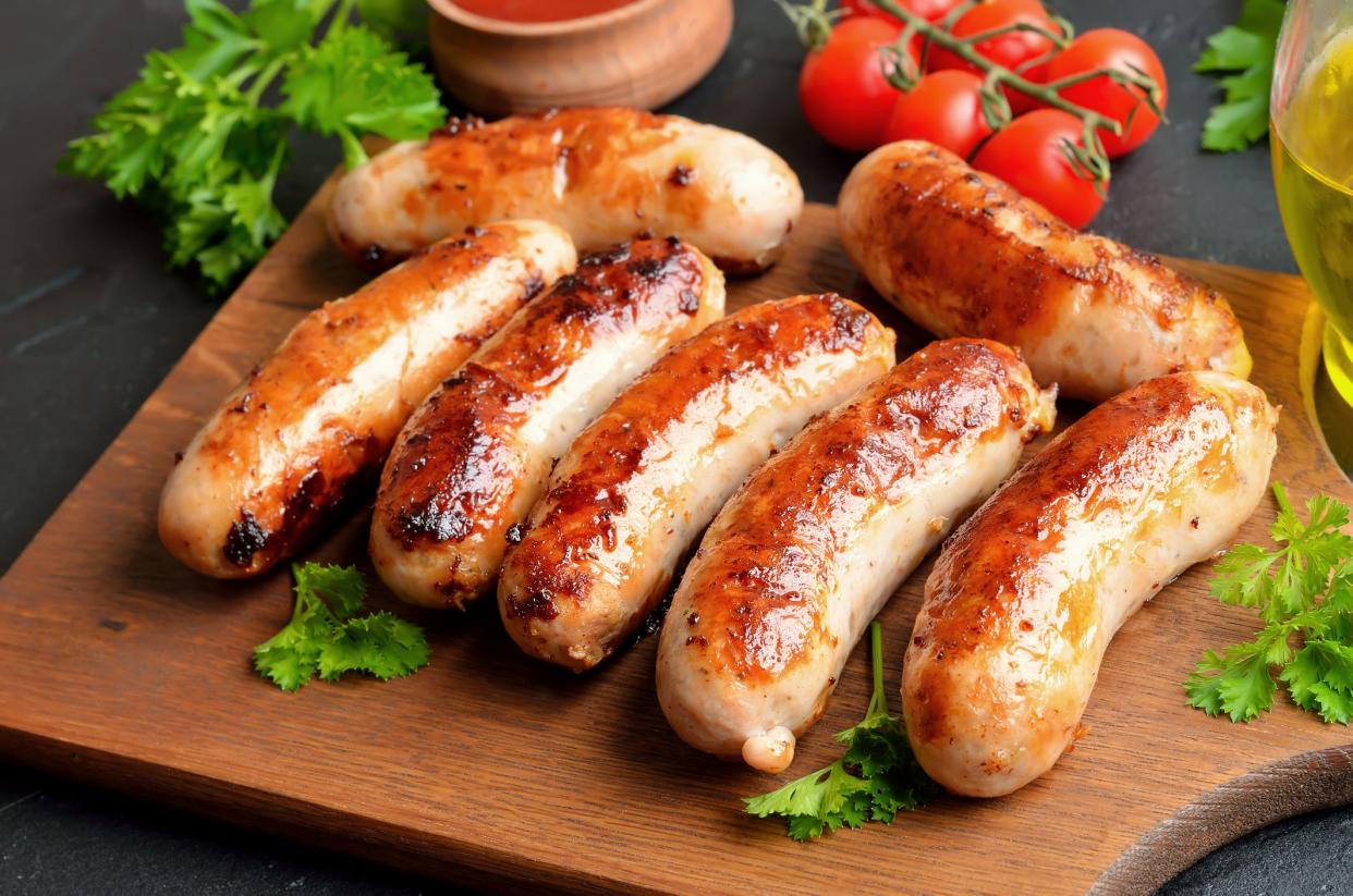 Homemade fried sausages on cutting board, close up view