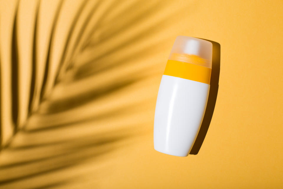 Bottle of sunscreen on a yellow background