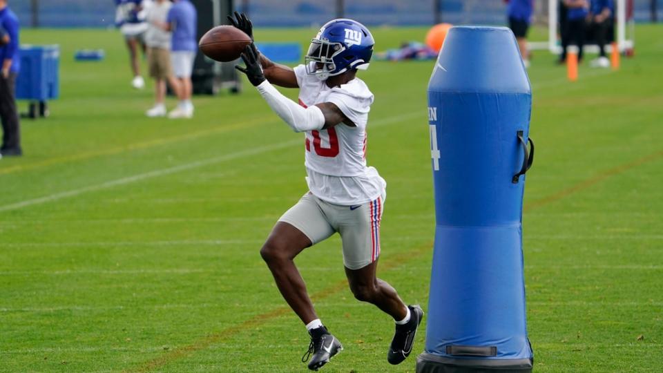 El esquinero de los New York Giants, Amani Oruwariye (20), atrapa el balón en el segundo día del minicampamento obligatorio en el centro de entrenamiento de los Giants el miércoles 14 de junio de 2023 en East Rutherford.