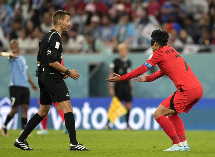 South Korea's Son Heung-min, right, discusses with referee Clement Turpin during the World Cup group H soccer match between Uruguay and South Korea, at the Education City Stadium in Al Rayyan , Qatar, Thursday, Nov. 24, 2022. (AP Photo/Lee Jin-man)