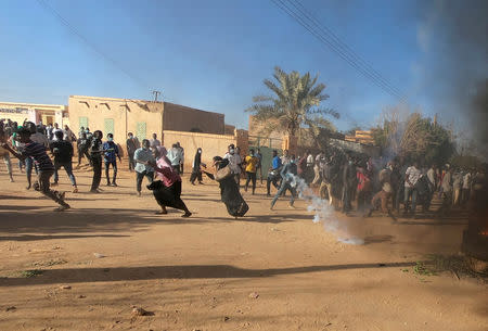 FILE PHOTO: Sudanese demonstrators run from a teargas canister fired by riot policemen to disperse them as they participate in anti-government protests in Omdurman, Khartoum, Sudan January 20, 2019. REUTERS/Mohamed Nureldin Abdallah/File Photo