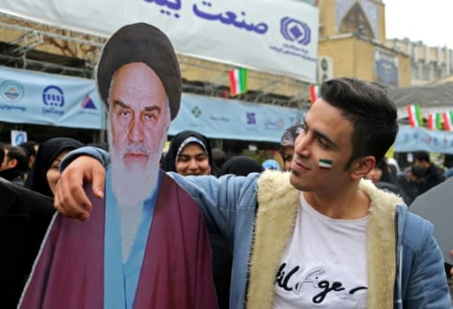 An Iranian man poses with a cutout of Ayatollah Ruhollah Khomeini during a ceremony celebrating the 40th anniversary of the revolution in the capital Tehran on February 11, 2019