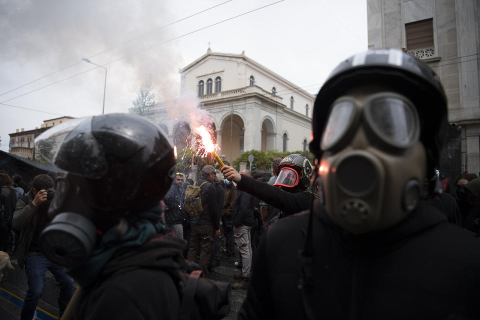 A protester holds a flare during a May Day rally in Athens, Greece, Monday, May 1, 2023. May Day protests took place in the Greek capital 20 days before the parliamentry elections 2023. (AP Photo/Michael Varaklas)