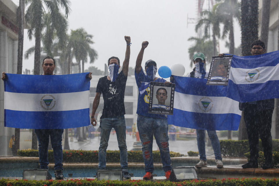 Demonstrators hold Nicaraguan national flags and photos of a slain students, during an anti-government march dubbed, "Nothing is Normal” in honor of Matt Romero, in Managua, Nicaragua, Saturday, Sept. 21, 2019. 16-year-old Matt Romero was killed during “crossfire” last September when armed men wearing hoods clashed with anti-government protesters. (AP Photo/Alfredo Zuniga)