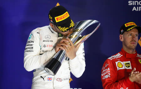 Motor Racing - Formula One - F1 Singapore Grand Prix 2018 - Singapore - September 16, 2018 Mercedes' Lewis Hamilton celebrates on theÊpodiumÊafter winning the race REUTERS/Kim Hong-Ji