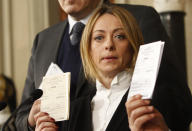 FILE — Fratelli d'Italia (Brothers of Italy) party lawmaker Giorgia Meloni shows her electoral card to journalists after talks with Italian President Giorgio Napolitano, at the Quirinale presidential palace, in Rome, Saturday, Feb. 15, 2014. With God, homeland and "natural" family prominent in her political manifesto, Giorgia Meloni, whose party with neo-fascist roots has been fast rising in popularity in view of the upcoming Sept. 25 elections for Parliament, is positioning herself to become Italy's first far-right premier and the first woman to hold that office. (AP Photo/Riccardo De Luca)