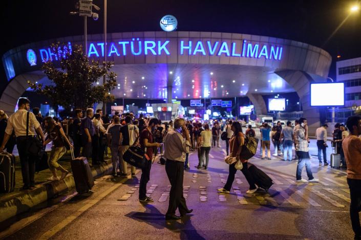 <p>People stand outside the entrance as they leave the airport after two explosions followed by gunfire hit the Turkey’s biggest airport of Ataturk in Istanbul, on June 28, 2016. (OZAN KOSE/AFP/Getty Images) </p>