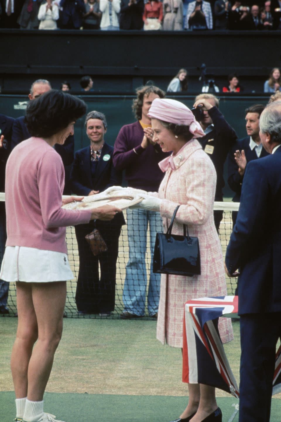 <p><strong>1977</strong> The Queen wore a pink-and-white ensemble to the women's final in 1977, before presenting the trophy.</p>