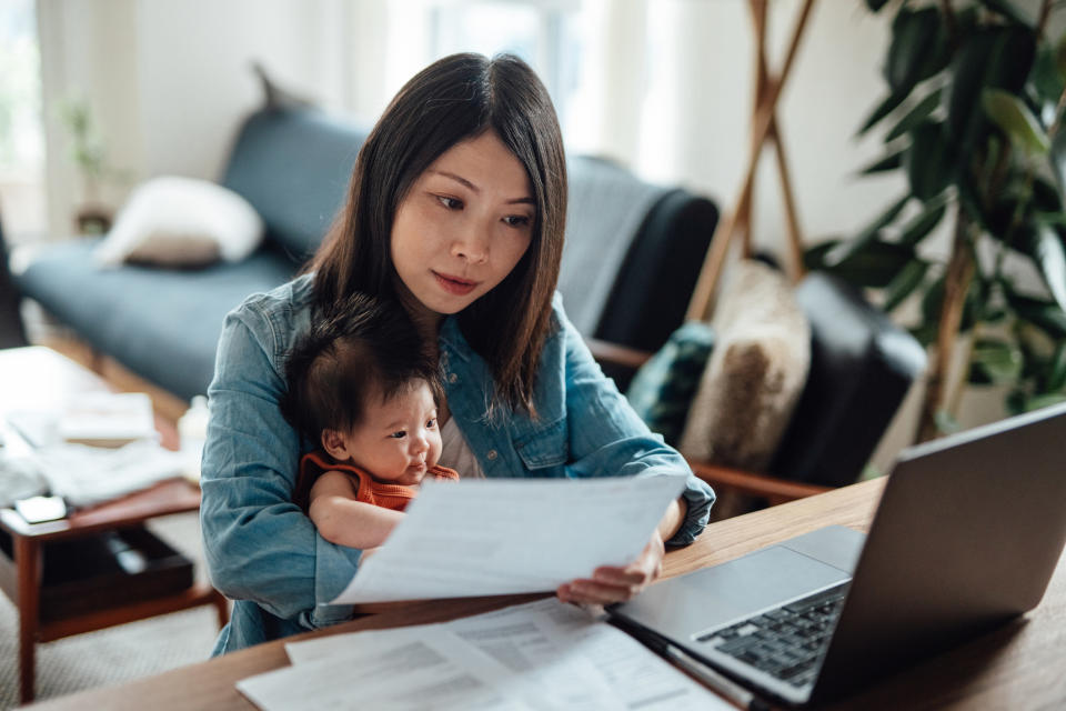 A woman at her desk with a baby in her lap